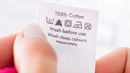 Close-up of a cotton bedding care label showing washing instructions and care symbols