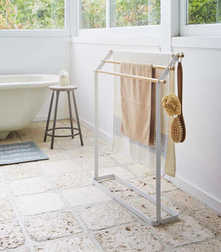 Bath towel hanging spread out on a rail between uses